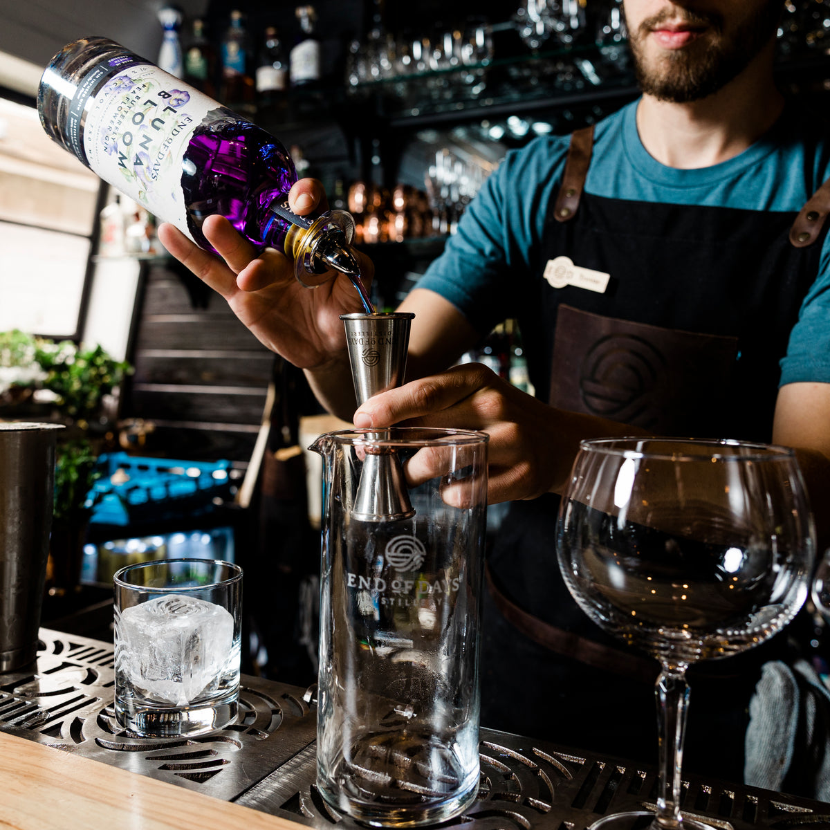 Bartender measuring Luna Bloom Butterfly Pea Flower Gin into a jigger behind the bar