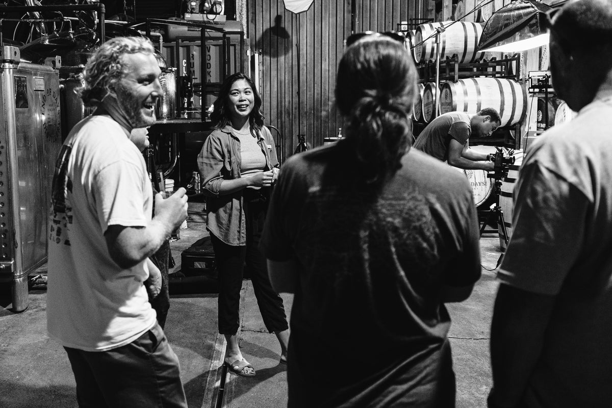 Guests on a distillery tour among stills and barrels at End of Days Distillery in Wilmington, NC.