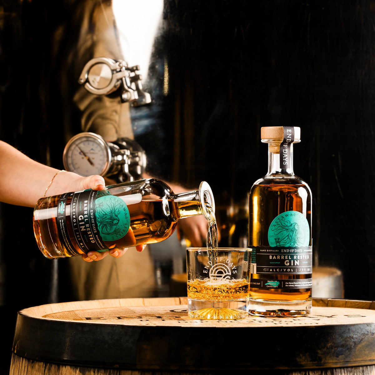 Barrel Rested Gin being poured into a rocks glass on top of an oak barrel beside the bottle